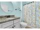 Bright bathroom with granite countertop, round mirror, and floral shower curtain at 418 Eastern Isle Ave, Summerville, SC 29486