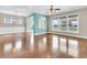 Bright living room featuring hardwood floors, large windows, and partial aqua-painted walls at 418 Eastern Isle Ave, Summerville, SC 29486