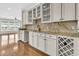 Attractive wet bar area featuring white cabinetry, granite countertops, tile backsplash, and hardwood flooring at 418 Eastern Isle Ave, Summerville, SC 29486