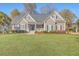 Inviting two-story home with well-maintained lawn and manicured landscaping, featuring a covered front porch at 4218 Club Course Dr, North Charleston, SC 29420