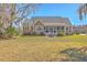 Charming single-story home featuring a lush front lawn, mature landscaping, and inviting front porch at 4218 Club Course Dr, North Charleston, SC 29420