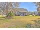 Charming home with a lush lawn, inviting screened porch, and mature trees adding to its curb appeal at 4218 Club Course Dr, North Charleston, SC 29420