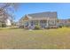 Back exterior of a charming home with a screened porch, patio, and lush green yard at 4218 Club Course Dr, North Charleston, SC 29420