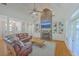 Open living room with a stone fireplace, built-in shelves, ceiling fan, and a comfortable leather sectional at 4218 Club Course Dr, North Charleston, SC 29420