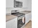 Modern kitchen with stainless steel appliances, white cabinets, and light countertops, showcasing a functional design at 446 White Scallop Way, Summerville, SC 29486
