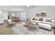 Open-concept living space with hardwood floors, neutral decor, and seamless flow to dining and kitchen at 446 White Scallop Way, Summerville, SC 29486