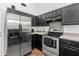 A modern kitchen features stainless steel appliances, dark cabinets, and wood flooring for a warm touch at 5024 Blair Rd, Summerville, SC 29483