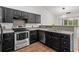 This spacious kitchen features stainless steel appliances and dark cabinets at 5024 Blair Rd, Summerville, SC 29483