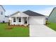 Charming single-Gathering home showcasing a well-manicured lawn, a two-car garage, and a welcoming front porch at 657 Cottage Landing Dr, Summerville, SC 29485