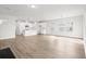 Bright, open-concept living space with modern lighting, hardwood floors, and a view into the kitchen with white cabinetry at 657 Cottage Landing Dr, Summerville, SC 29485