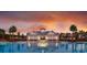 Community pool and clubhouse with a beautiful orange, yellow and purple sunset with some palm trees at 657 Cottage Landing Dr, Summerville, SC 29485