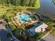 Aerial view of a community pool with pergolas, a splashpad, lounge seating, and nearby playground at 707 Redbud Ln, Summerville, SC 29486