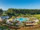 Expansive community pool surrounded by lush landscaping, a playground, and comfortable seating areas at 707 Redbud Ln, Summerville, SC 29486