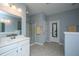 Bright bathroom featuring a large mirror, double sink vanity, glass-enclosed shower, and tile flooring at 718 Kilarney Rd, Summerville, SC 29483