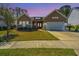 Charming home with a well-manicured lawn, a red front door and a two car garage at dusk at 718 Kilarney Rd, Summerville, SC 29483