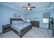 Comfortable main bedroom with blue walls, carpet, tray ceiling, ceiling fan, and a dark wood bed with floral bedding at 718 Kilarney Rd, Summerville, SC 29483