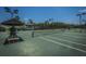 Well-maintained tennis courts with lighting for evening play and a covered bench area at 718 Kilarney Rd, Summerville, SC 29483