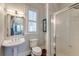 Bathroom with a glass-enclosed shower, pedestal sink, decorative wallpaper, and reflective mirror at 724 Hibbens Grant Blvd, Mount Pleasant, SC 29464