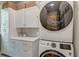 Modern laundry room with stacked washer and dryer, white cabinets, and gray backsplash at 724 Hibbens Grant Blvd, Mount Pleasant, SC 29464