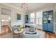 Bright home office with wainscoting, modern chandelier, hardwood floors, and blue shelving at 724 Hibbens Grant Blvd, Mount Pleasant, SC 29464