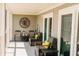 Relaxing covered balcony with comfortable seating, a clock and stylish decor to enjoy the outdoors at 76 Mariners Cay Dr, Folly Beach, SC 29439