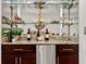 Stylish bar area with granite countertop, mini fridge, and glass shelving for display at 76 Mariners Cay Dr, Folly Beach, SC 29439