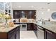 Modern kitchen with stainless appliances, dark wood cabinets, granite counters, and stylish backsplash at 76 Mariners Cay Dr, Folly Beach, SC 29439