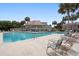 Relaxing community pool with ample seating and plenty of palm trees providing shade on a sunny day at 76 Mariners Cay Dr, Folly Beach, SC 29439