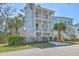 Charming three-story coastal home featuring double balconies, a lush yard, and a private garage at 824 Forrest Dr, Charleston, SC 29492