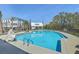 Community pool with clear blue water, lounge chairs and umbrellas, perfect for relaxation at 824 Forrest Dr, Charleston, SC 29492
