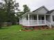 Charming home with a covered porch, a well-maintained lawn, and a paved driveway at 8309 Berringer Bluff, North Charleston, SC 29418