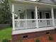 Inviting covered front porch with white railing, showcasing the home's exterior details and curb appeal at 8309 Berringer Bluff, North Charleston, SC 29418