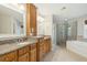 Bathroom with double vanity, granite countertop, walk-in shower and a soaking tub at 8716 Dover Creek St, North Charleston, SC 29420