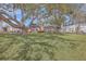 Spacious backyard with mature trees, a brick home with a wooden deck, and plenty of room for outdoor recreation at 886 Piccadilly Cir, Charleston, SC 29412
