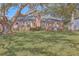 Large backyard with mature trees, a brick home with a wooden deck, and a swing set for outdoor enjoyment at 886 Piccadilly Cir, Charleston, SC 29412