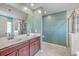 A dual-sink vanity, a soaking tub and glass-walled shower enhance this bathroom at 9988 Winged Elm St, Ladson, SC 29456