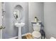Stylish half bathroom with a pedestal sink, modern toilet, and sleek wood-look floors at 9988 Winged Elm St, Ladson, SC 29456