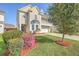 Inviting two-story home with a covered porch and beautifully landscaped front yard with flowers at 9988 Winged Elm St, Ladson, SC 29456