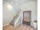 Inviting foyer showcasing wood floors, a staircase, and stylish coat rack with storage at 9988 Winged Elm St, Ladson, SC 29456