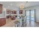 Eat-in kitchen features stainless appliances, granite counters, wooden cabinetry, and outdoor access at 9988 Winged Elm St, Ladson, SC 29456