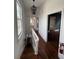 Hallway with stairs, light fixture, freshly finished hardwood floors, and natural light from the windows at 101 Queen St, Charleston, SC 29401