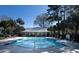 Community pool with crystal-clear water, palm trees, and a pool house, perfect for leisure and recreation at 1025 Riverland Woods Pl # 907, Charleston, SC 29412