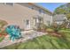 A cozy backyard patio with a grill, bright chairs, lush lawn, and well-maintained landscaping at 103 Sago Palm Ct, Summerville, SC 29483