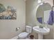 Half bathroom with stylish round mirror, modern sink, and neutral decor at 103 Sago Palm Ct, Summerville, SC 29483