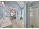 Bathroom showcases a shower, tub, dual sinks with white cabinets, and blue walls at 103 Sago Palm Ct, Summerville, SC 29483