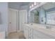 Bathroom featuring dual sinks, white cabinets, a large mirror, a window, and blue walls at 103 Sago Palm Ct, Summerville, SC 29483