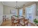 Dining room with a large wooden table, chandelier, and windows providing natural light at 103 Sago Palm Ct, Summerville, SC 29483