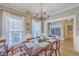 Elegant dining room with natural light, hardwood flooring, and doorway to book-lined office at 103 Sago Palm Ct, Summerville, SC 29483