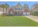 Charming two-story brick home with a well-manicured lawn, palm trees, and a two-car garage at 103 Sago Palm Ct, Summerville, SC 29483