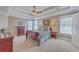 Spacious main bedroom with a tray ceiling, two windows, a ceiling fan, and dark wood furniture at 103 Sago Palm Ct, Summerville, SC 29483